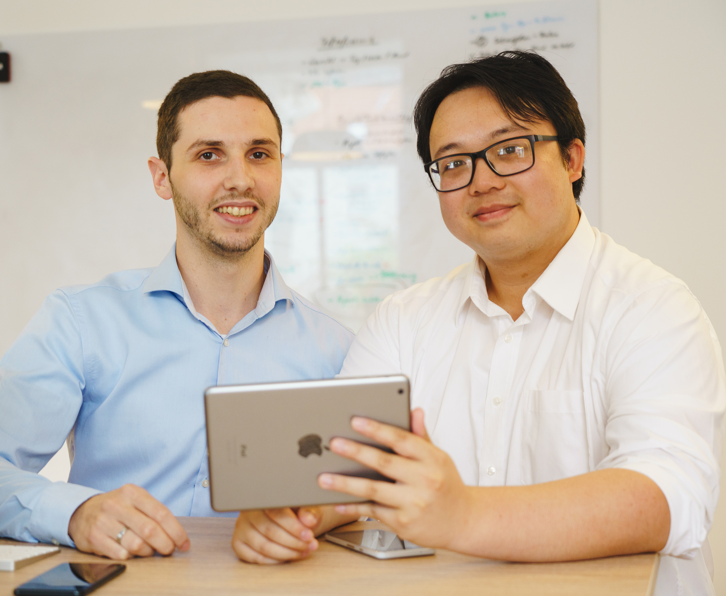 Zwei Softwareentwickler bei der gemeinsamen Projektbesprechung mit Tablet – Beispiel für Expert-as-a-Service-Unterstützung durch die Cayas App-Agentur.
